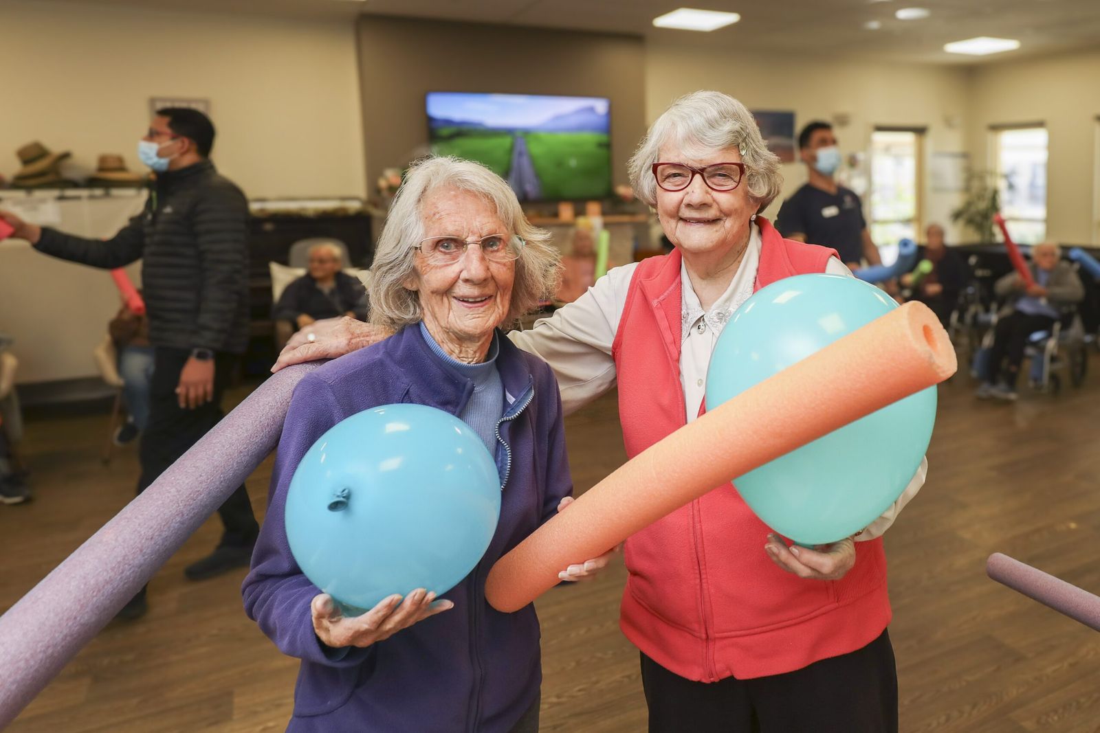 Two residents smiling with balloons during a games session