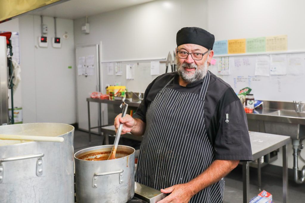 The Princes Court chef stirring a large pot in the kitchen