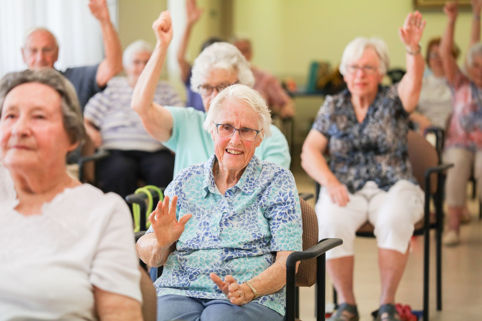 Residents laughing and raising their arms during an exercise class