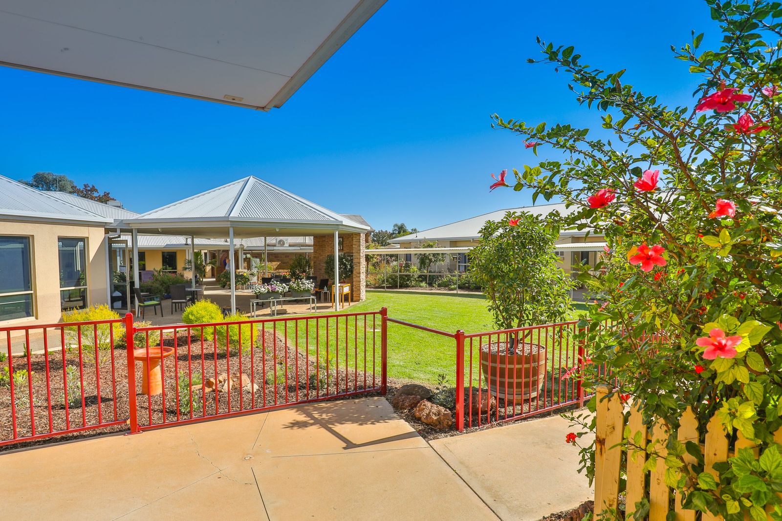 A gazebo and flowering gardens under a blue sky