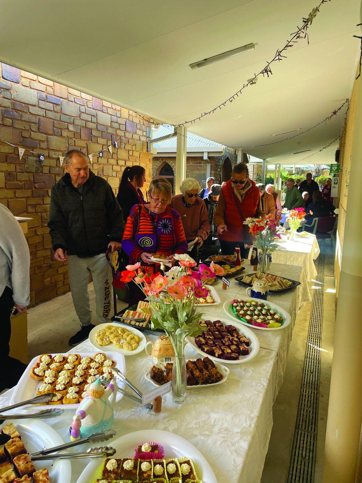 Residents and visitors gathering around a table of food at a celebration
