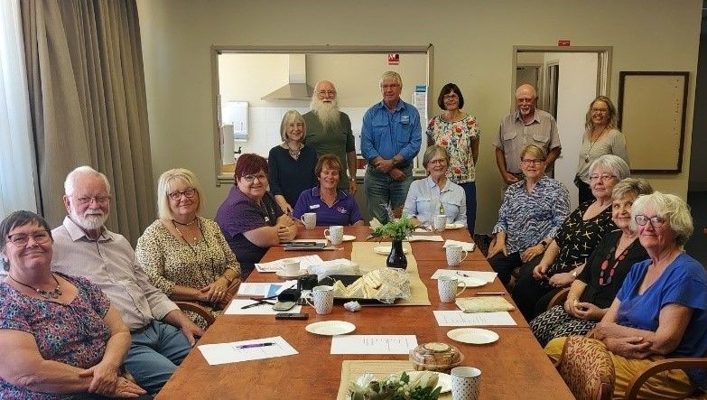 A group gathered around a long table, chatting and sharing stories